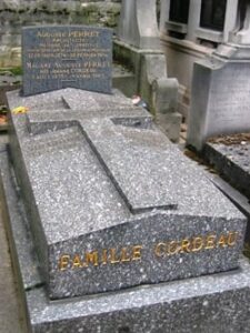 Une tombe en pierre grise avec une croix en relief et des lettres dorées indiquant "FAMILLE GORDEAU", avec une inscription pour Adolphe Perret et Maurice Auguste Perret à l'arrière-plan, évoque l'histoire du vieux Paris, comme une photo ancienne prise sur le vif.