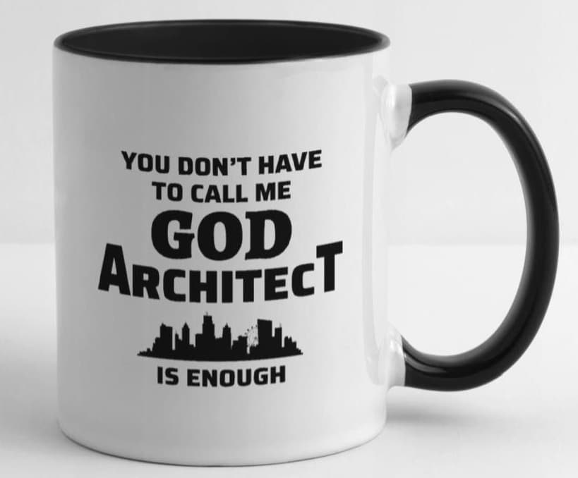 Mug blanc avec anse noire comportant le texte "You have not have call me God, Architect is enough" au-dessus d'une silhouette de ville : "Vous n'avez pas besoin de m'appeler Dieu, l'architecte suffit" au-dessus d'une silhouette de ville.